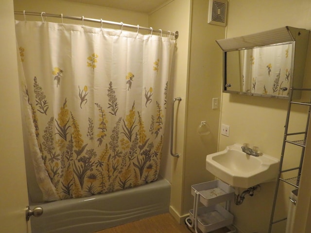 236 S Jeffery Ave, Ithaca, MI 48847 - full bath with a sink, shower / bath combo, and wood finished floors