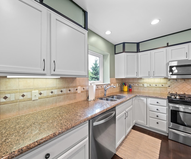 702 Starfield Dr, Pinckney, MI 48169 - kitchen with appliances with stainless steel finishes, a sink, white cabinetry, light stone countertops, and tasteful backsplash