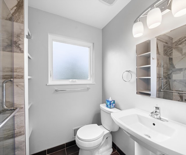 702 Starfield Dr, Pinckney, MI 48169 - bathroom featuring a sink, toilet, a shower stall, and tile patterned flooring