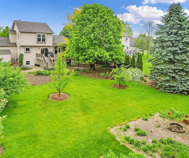 702 Starfield Dr, Pinckney, MI 48169 - view of green lawn featuring a fire pit, stairway, and a wooden deck
