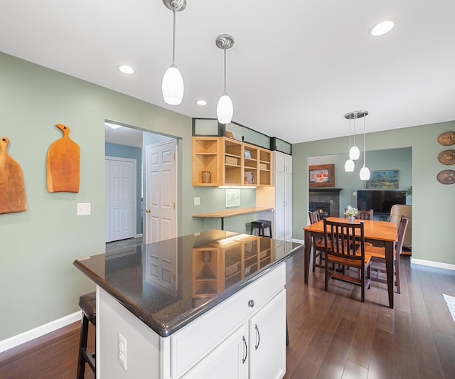 702 Starfield Dr, Pinckney, MI 48169 - kitchen featuring white cabinets, a fireplace, baseboards, dark wood-style floors, and recessed lighting