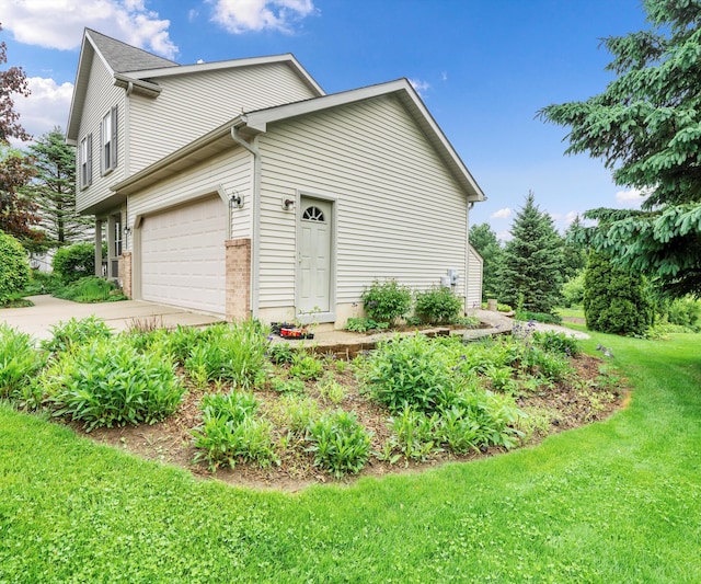 702 Starfield Dr, Pinckney, MI 48169 - view of side of home featuring driveway, a yard, an attached garage, and brick siding
