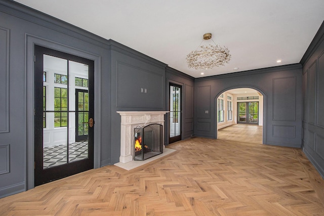 310 Lakeside Dr SE, East Grand Rapids, MI 49506 - unfurnished living room featuring a decorative wall, arched walkways, a lit fireplace, crown molding, and recessed lighting