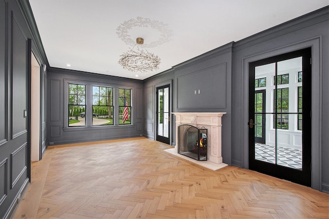 310 Lakeside Dr SE, East Grand Rapids, MI 49506 - unfurnished living room with a decorative wall, a lit fireplace, crown molding, recessed lighting, and a chandelier