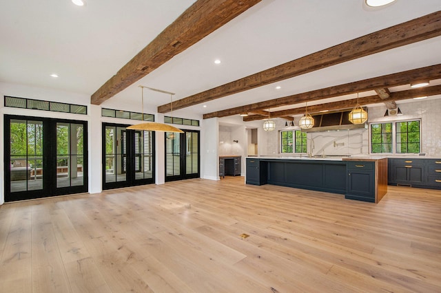 310 Lakeside Dr SE, East Grand Rapids, MI 49506 - kitchen with open floor plan, light countertops, backsplash, light wood-style flooring, and beamed ceiling