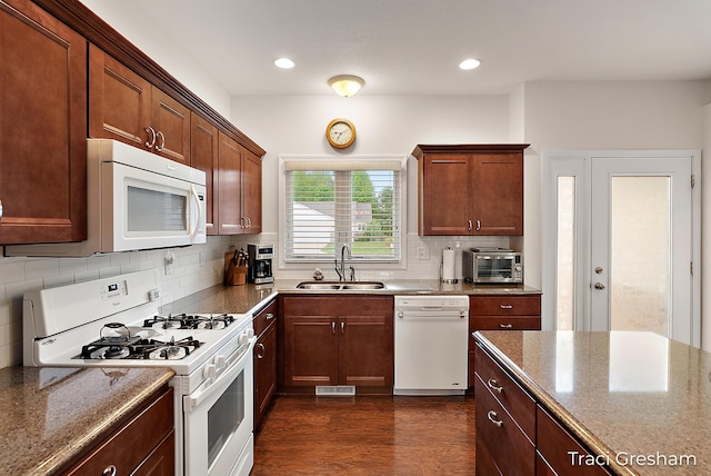 1733 Grevel Ct, Muskegon, MI 49444 - kitchen featuring white appliances, a sink, dark wood-style floors, backsplash, and dark stone countertops