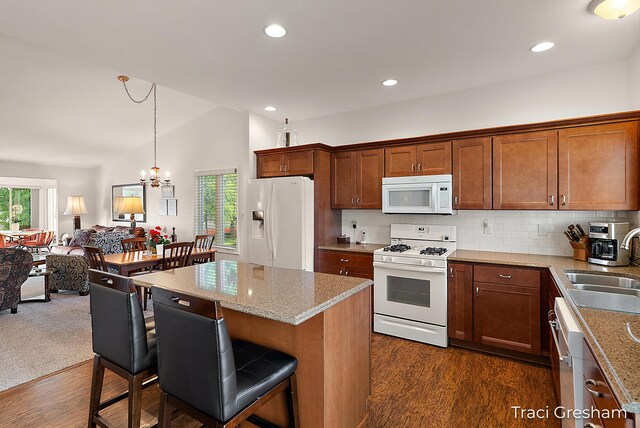 1733 Grevel Ct, Muskegon, MI 49444 - kitchen with white appliances, a sink, a kitchen bar, dark wood-style floors, and healthy amount of natural light
