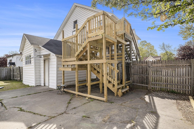 706 N Linn St, Bay City, MI 48706 - back of property with stairway, a fenced backyard, a shingled roof, a patio area, and a wooden deck