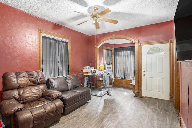 706 N Linn St, Bay City, MI 48706 - living room with a ceiling fan, a textured wall, wood finished floors, a textured ceiling, and arched walkways