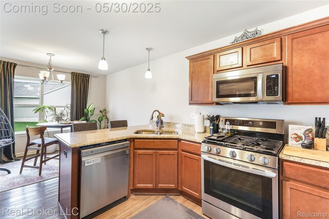4428 Cross Creek Blvd, Burton, MI 48509 - kitchen with appliances with stainless steel finishes, a sink, a peninsula, light wood-type flooring, and pendant lighting