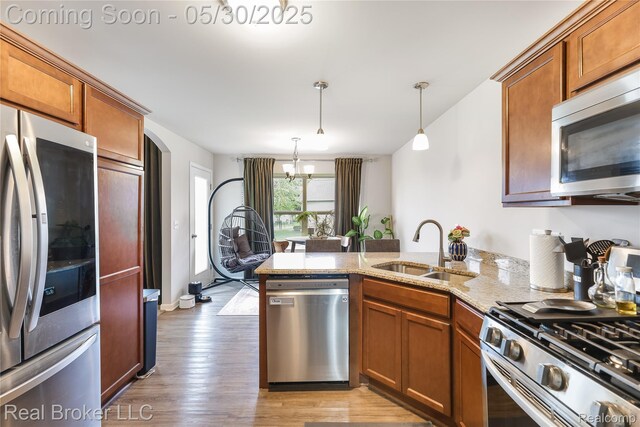 4428 Cross Creek Blvd, Burton, MI 48509 - kitchen with stainless steel appliances, a sink, a peninsula, and brown cabinetry