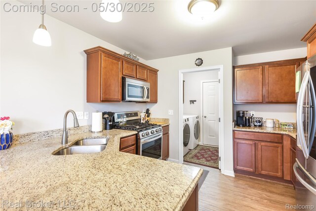 4428 Cross Creek Blvd, Burton, MI 48509 - kitchen with washer and dryer, appliances with stainless steel finishes, a sink, and light stone counters