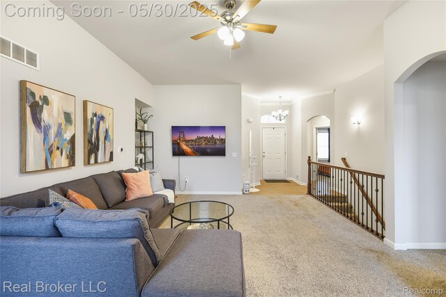 4428 Cross Creek Blvd, Burton, MI 48509 - carpeted living area with arched walkways, a ceiling fan, a chandelier, and baseboards