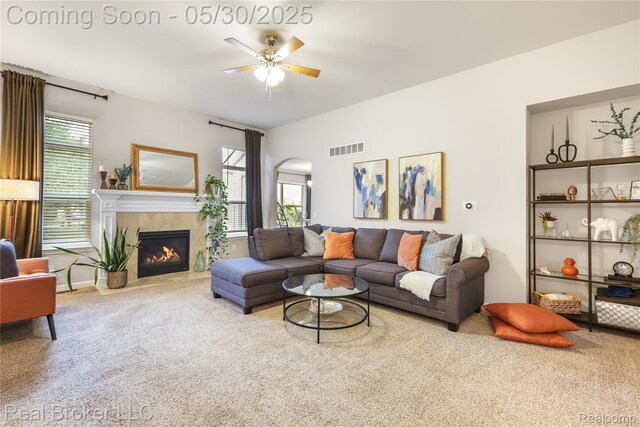 4428 Cross Creek Blvd, Burton, MI 48509 - living area featuring carpet floors, ceiling fan, arched walkways, and a tiled fireplace