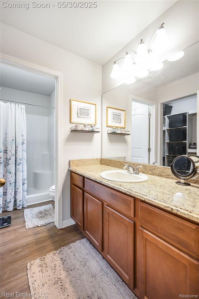 4428 Cross Creek Blvd, Burton, MI 48509 - bathroom with vanity, wood finished floors, a shower with shower curtain, and toilet