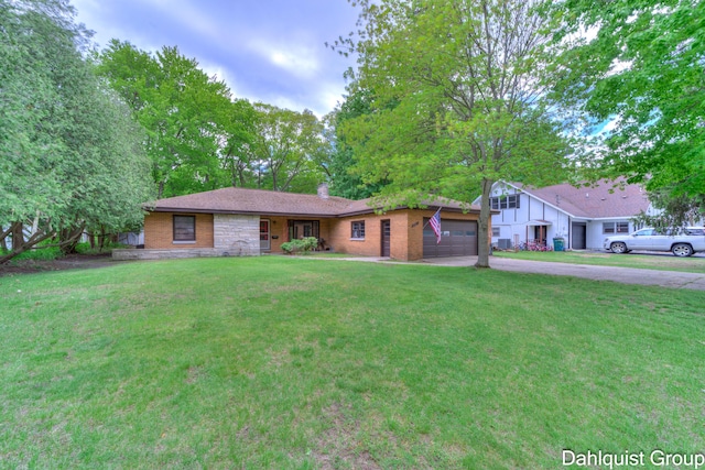 2587 Pennsylvania Ave, Muskegon, MI 49445 - ranch-style home with driveway, an attached garage, a front lawn, a chimney, and brick siding