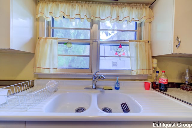2587 Pennsylvania Ave, Muskegon, MI 49445 - kitchen view of a sink, light countertops, and white cabinetry