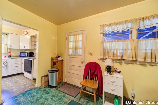 2587 Pennsylvania Ave, Muskegon, MI 49445 - kitchen with white range with electric stovetop and white cabinets