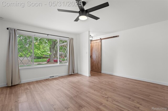 27677 Doreen St, Farmington Hills, MI 48336 - unfurnished room featuring a barn door, wood finished floors, a ceiling fan, and baseboards