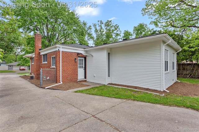 27677 Doreen St, Farmington Hills, MI 48336 - view of front of home with brick siding, a chimney, and concrete driveway