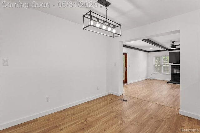27677 Doreen St, Farmington Hills, MI 48336 - unfurnished dining area featuring a ceiling fan, baseboards, light wood-style floors, a glass covered fireplace, and beam ceiling