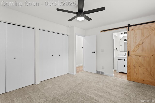 27677 Doreen St, Farmington Hills, MI 48336 - unfurnished bedroom featuring a barn door, two closets, carpet floors, connected bathroom, and baseboards