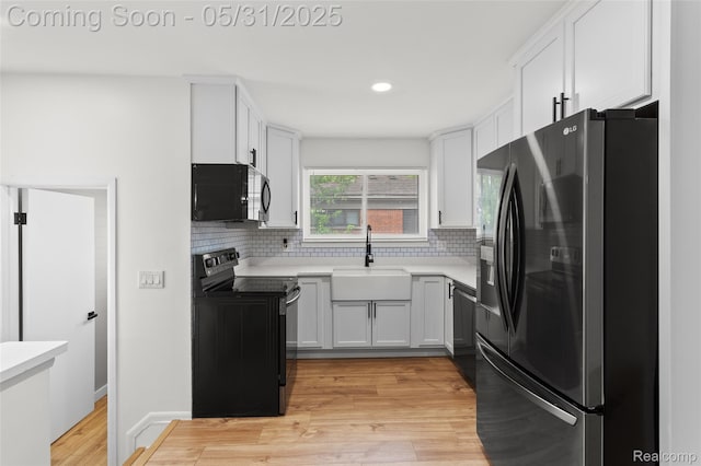 27677 Doreen St, Farmington Hills, MI 48336 - kitchen featuring black appliances, a sink, tasteful backsplash, light wood finished floors, and light countertops