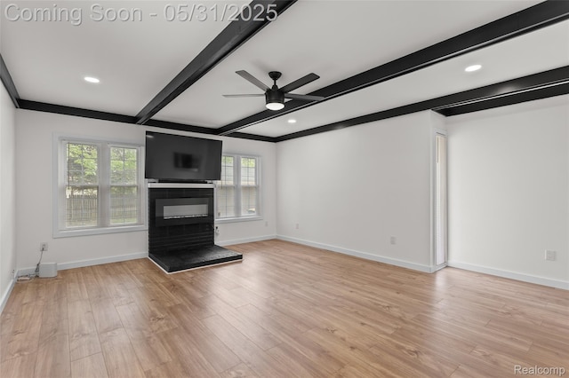 27677 Doreen St, Farmington Hills, MI 48336 - unfurnished living room featuring beam ceiling, ceiling fan, baseboards, a glass covered fireplace, and light wood-style flooring