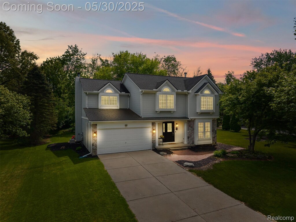 6248 Lake Waldon Ct, Clarkston, MI 48346 - traditional-style house featuring stone siding, driveway, a front lawn, and a chimney