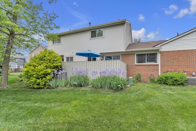 2840 Bombridge Ct, Ann Arbor, MI 48104 - back of property with brick siding, a yard, cooling unit, and roof with shingles