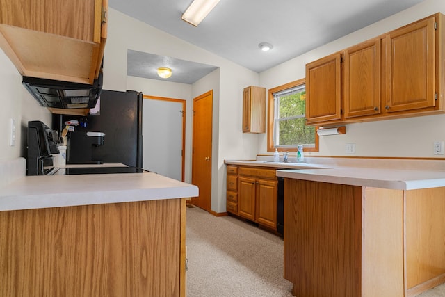 2041 Blackmer Dr, Jonesville, MI 49250 - kitchen featuring lofted ceiling, a peninsula, light countertops, light colored carpet, and freestanding refrigerator