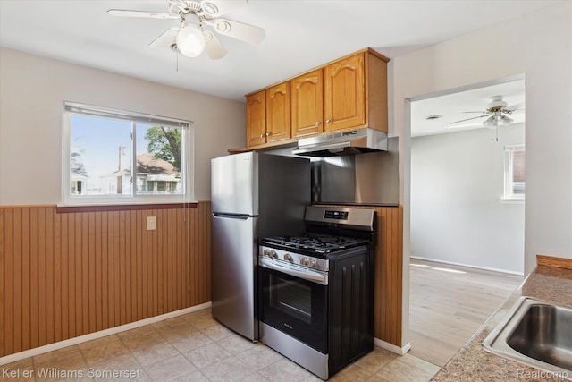 1623 Ethel Ave, Lincoln Park, MI 48146 - kitchen featuring stainless steel appliances, under cabinet range hood, a ceiling fan, wainscoting, and brown cabinetry