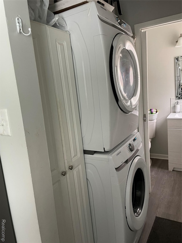 1808 Henbert, West Bloomfield, MI 48324 - laundry room with stacked washing machine and dryer, wood finished floors, and baseboards