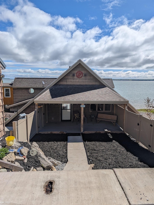 1422 Sims St, De Tour Village, MI 49725 - view of front of property with a gate, a shingled roof, a water view, and covered porch