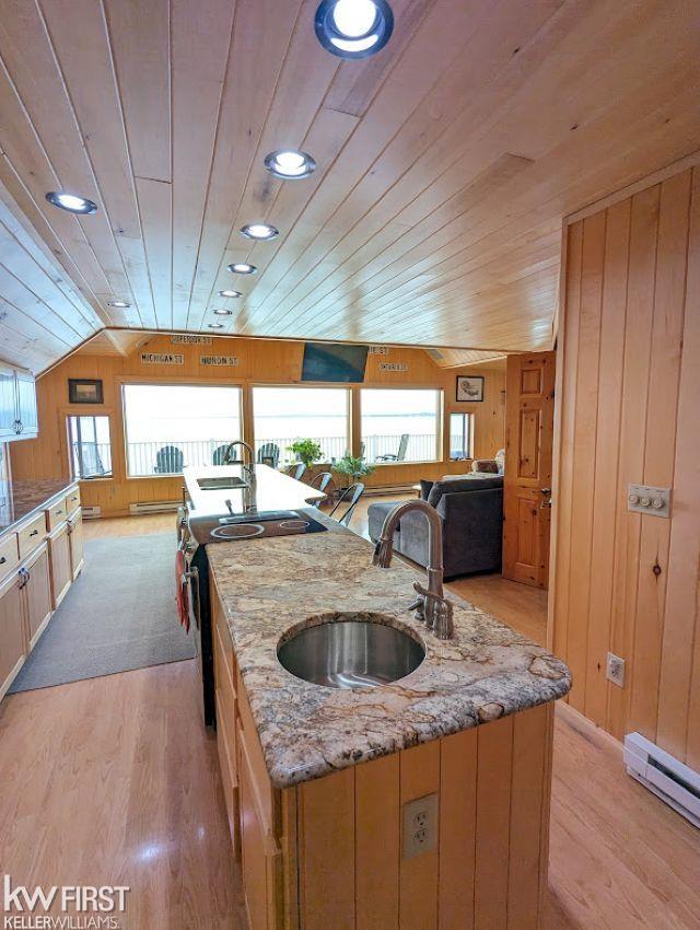 1422 Sims St, De Tour Village, MI 49725 - kitchen with a sink, stainless steel range with electric cooktop, a baseboard radiator, wood ceiling, and a center island with sink