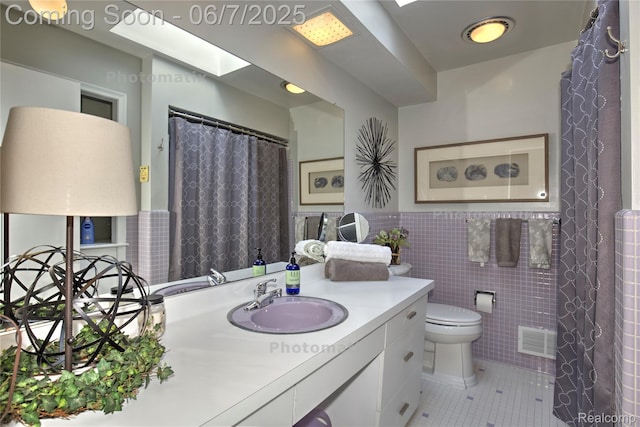 11555 Colpaert Dr, Warren, MI 48093 - full bath with tile patterned flooring, vanity, tile walls, toilet, and a wainscoted wall