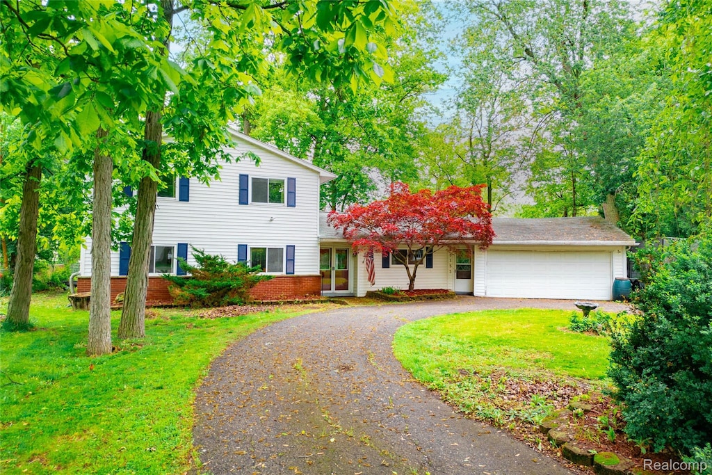 25155 Dallas Dr, Grosse Ile, MI 48138 - traditional-style home featuring curved driveway, a front yard, a garage, and brick siding