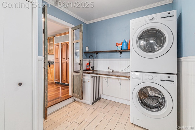 687 Sunnybeach Dr, White Lake, MI 48386 - washroom featuring stacked washer / dryer, ornamental molding, a wainscoted wall, and light wood finished floors