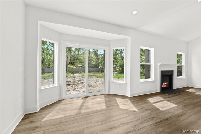 11308 Merriman Rd, Livonia, MI 48150 - unfurnished living room featuring plenty of natural light, wood finished floors, a fireplace with flush hearth, baseboards, and recessed lighting