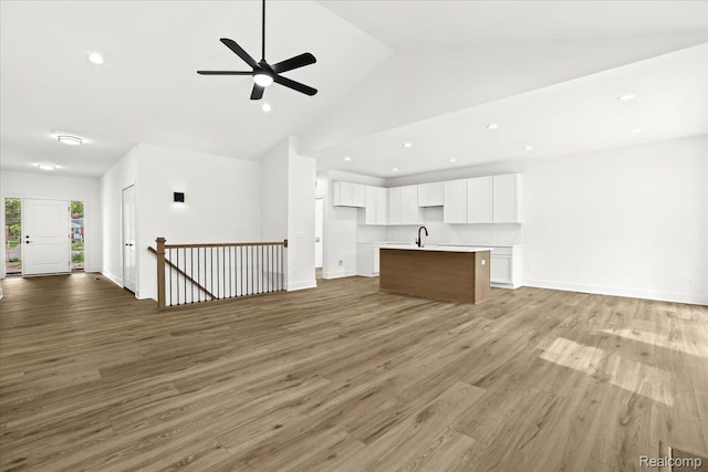 11308 Merriman Rd, Livonia, MI 48150 - unfurnished living room with high vaulted ceiling, ceiling fan, recessed lighting, wood finished floors, and baseboards