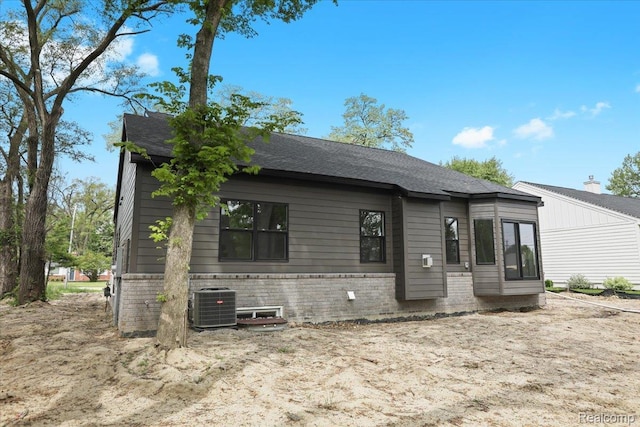 11308 Merriman Rd, Livonia, MI 48150 - view of front of property with brick siding, central AC unit, and roof with shingles