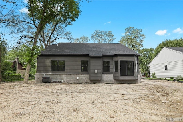 11308 Merriman Rd, Livonia, MI 48150 - back of house featuring cooling unit, brick siding, and a shingled roof