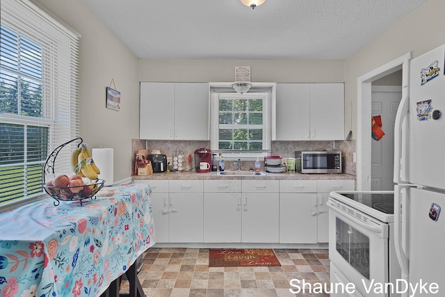 88 Violet St SW, Grand Rapids, MI 49548 - kitchen featuring white appliances, a sink, light countertops, backsplash, and a textured ceiling