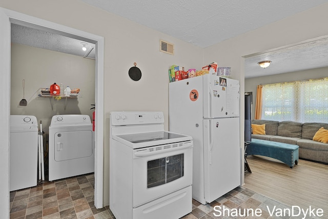 88 Violet St SW, Grand Rapids, MI 49548 - kitchen featuring freestanding refrigerator, washer and clothes dryer, a textured ceiling, and stone finish floors