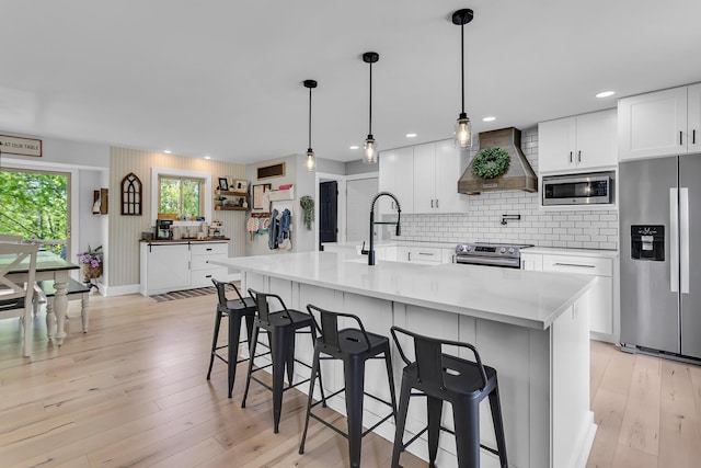 9275 M-50, Onsted, MI 49265 - kitchen with appliances with stainless steel finishes, wall chimney exhaust hood, a sink, a kitchen breakfast bar, and recessed lighting