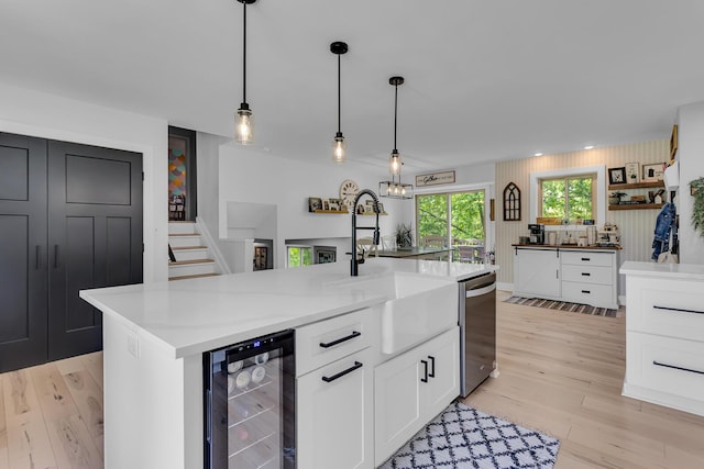 9275 M-50, Onsted, MI 49265 - kitchen featuring beverage cooler, a sink, stainless steel dishwasher, white cabinets, and light wood-type flooring