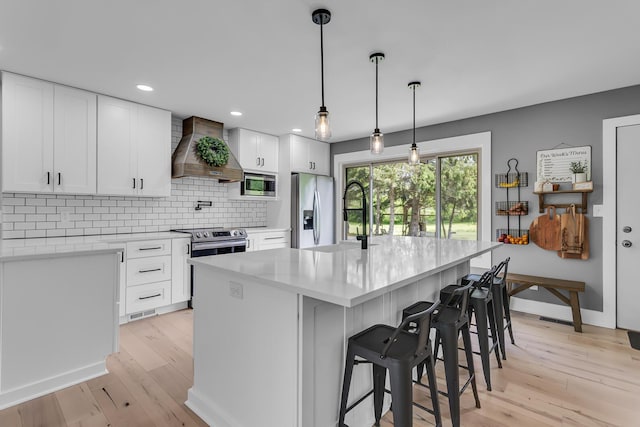 9275 M-50, Onsted, MI 49265 - kitchen with wall chimney exhaust hood, stainless steel appliances, light wood finished floors, tasteful backsplash, and recessed lighting