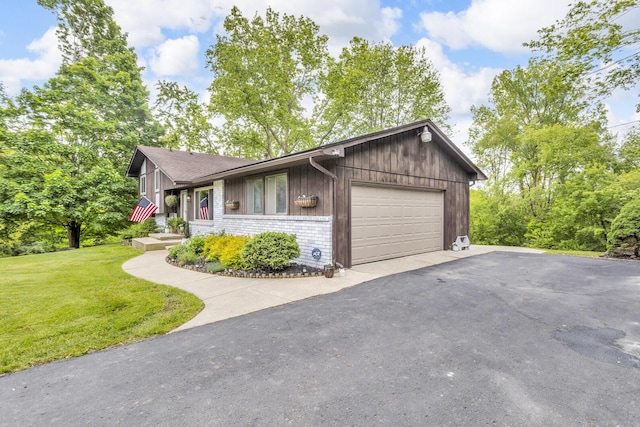 9275 M-50, Onsted, MI 49265 - view of front of home featuring an attached garage, a front lawn, asphalt driveway, and brick siding