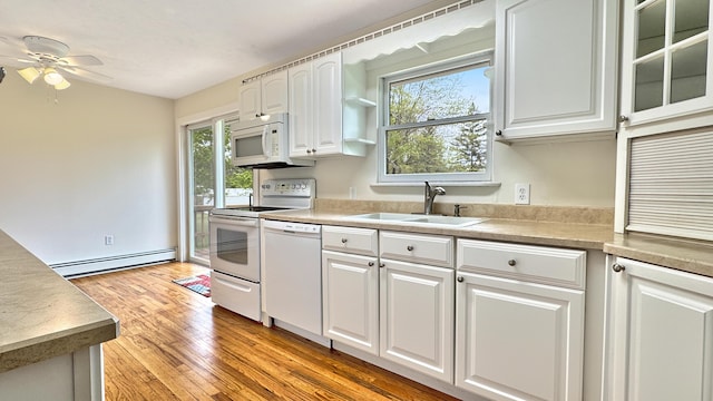 1972 W Cedar Dr, Mcbain, MI 49657 - kitchen featuring a sink, white appliances, a baseboard radiator, a ceiling fan, and white cabinets