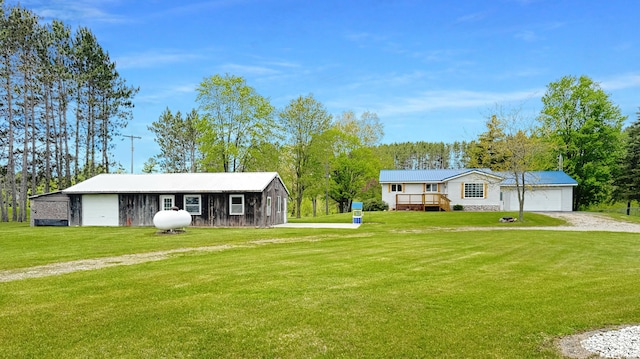 1972 W Cedar Dr, Mcbain, MI 49657 - view of front facade featuring driveway, a front lawn, a detached garage, and an outdoor structure